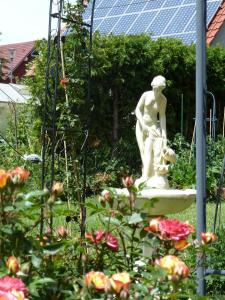 a statue of a man with a dog in a garden at An der Uferpromenade in Worbis