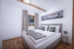 um quarto com uma grande cama branca num quarto em Apartment Streif LXL em Kirchdorf in Tirol