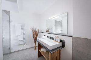 Baño blanco con lavabo y espejo en Apartment Streif LXL en Kirchdorf in Tirol