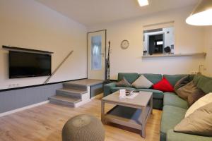 Ferienhaus FREE WILLI في فيلنغن: غرفة معيشة مع أريكة وتلفزيون بشاشة مسطحة