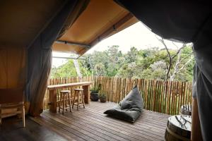 a porch with a table and a wooden fence at Metung Hot Springs in Metung