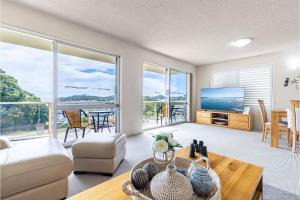 ein Wohnzimmer mit einem Sofa und einem Tisch in der Unterkunft Laman Lodge, 1,15 Laman Street - Stunning Views, air conditioned unit with water views and Wifi in Nelson Bay