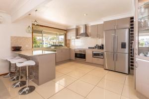 a kitchen with stainless steel appliances and tile floors at Waterfront Haven with your own private jetty in Forster