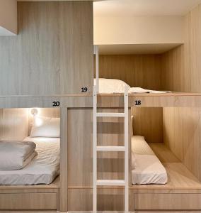 two bunk beds in a small room with numbered shelves at 婧仕女微旅 in Hou-lung-tzu