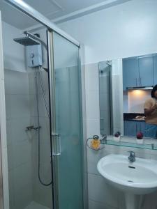 a bathroom with a shower and a sink and a mirror at Sea Residences MOA Complex - Ruffa's Condotel in Manila