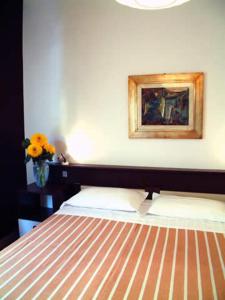 sypialnia z łóżkiem i obrazem na ścianie w obiekcie Bridge Hotel w mieście Bagni di Lucca