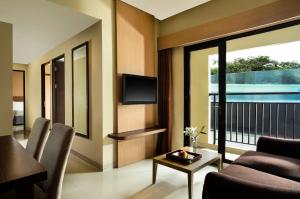a living room with a tv and a couch and a table at Atria Residences Gading Serpong in Serpong