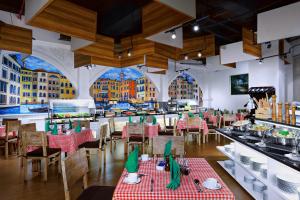 a dining room with tables and chairs in a restaurant at Atria Residences Gading Serpong in Serpong