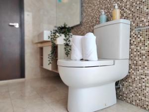 a white toilet in a bathroom with towels at Element Signature Suites 5pax 3Br Ampang KLCC in Kuala Lumpur