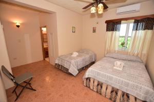 1 dormitorio con 2 camas, silla y ventana en Harada Inn and Suites, en Hopkins