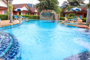 a large swimming pool with a water fountain at Andaman Seaside Resort - SHA Extra Plus in Bang Tao Beach
