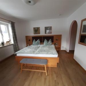Schlafzimmer mit einem großen Bett mit einem Kopfteil aus Holz in der Unterkunft Ferienwohnungen Haus Martin in Inzell