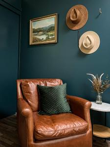 a brown leather chair in a room with a hat at Westwood Lodge in Bright