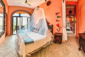 a bedroom with a bed with a mosquito net at Casa Flourish, Yelapa in Yelapa