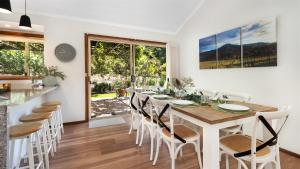 a dining room with a table and chairs at Banksia in West Cambewarra