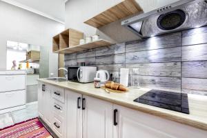 a kitchen with white cabinets and a counter top at Уютная квартира в центре города in Astana