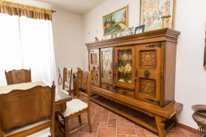 a room with a large wooden cabinet and chairs at Patrian in Grottaferrata