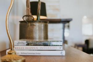 drie boeken op een tafel naast een lamp bij Corunna Station Country House in Belford