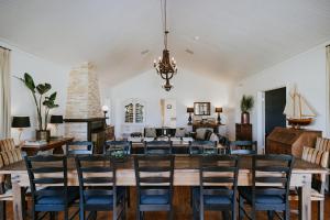 een eetkamer met een grote houten tafel en stoelen bij Corunna Station Country House in Belford