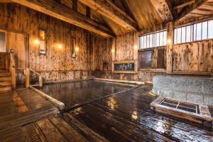 an empty room with wooden walls and a wooden floor at Tsuta Onsen Ryokan in Towada