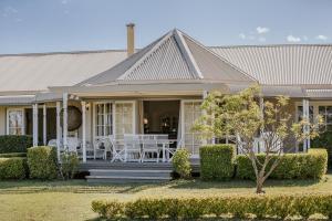 ein Haus mit einer Veranda mit einem Tisch und Stühlen in der Unterkunft Corunna Station Country House in Belford