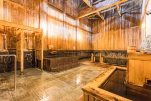 a large room with wooden walls and a bath tub at Tsuta Onsen Ryokan in Towada