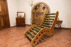 a wooden couch sitting in a room with a door at Patrian in Grottaferrata