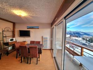 a dining room with a table and a balcony at Appartement Saint-Michel-de-Chaillol, 2 pièces, 6 personnes - FR-1-393-51 in Saint-Michel-de-Chaillol