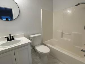 uma casa de banho com um WC, um lavatório e um espelho. em Private rooms near I-30 mesquite em Dallas