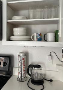 a kitchen counter with a cupboard with plates and dishes at Private rooms near I-30 mesquite in Dallas