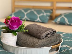 a white basket with towels and a flower on a bed at Private rooms near I-30 mesquite in Dallas