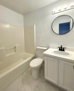 a bathroom with a toilet and a sink and a mirror at Private rooms near I-30 mesquite in Dallas