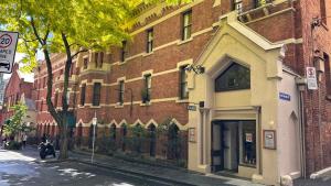 un edificio in mattoni su una strada di città vicino a un marciapiede di Gordon House Apartments a Melbourne