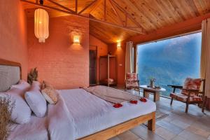 sypialnia z dużym łóżkiem i dużym oknem w obiekcie Seclude Pangot, Perch w mieście Nainital