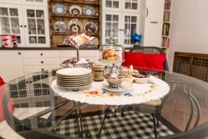 a glass table with plates and dishes on it at Patrian in Grottaferrata