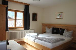 Schlafzimmer mit einem Bett und einem Fenster in der Unterkunft Gasthof zum Stern in Oetz