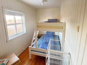 a small room with a bunk bed and a window at Holiday home byrknesøy in Ånneland