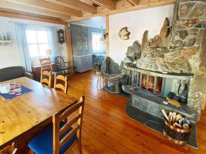 a living room with a fireplace and a dining room table at Holiday home byrknesøy in Ånneland