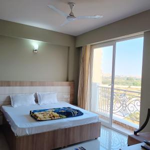 a bedroom with a bed and a large window at Radhe Krishna Luxury stay in Mathura