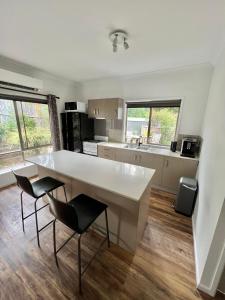 una cocina con una gran mesa blanca y 2 sillas en Berghofen, en Mount Tamborine