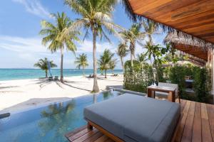 Irene Pool Villa Resort, Koh Lipe في كو ليبي: منتجع فيه مسبح وشاطئ فيه نخيل