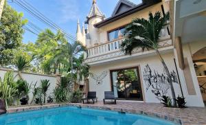 POTTERLAND Luxury Pool Villa Pattaya Walking Street 6 Bedrooms في جنوب باتايا: منزل به مسبح امام مبنى