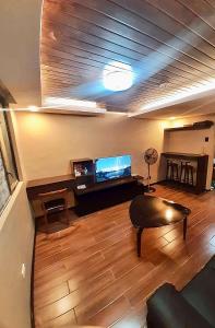Sala de estar con sofá, TV y mesa en IV’s Condo w/ Netflix and Wi-Fi, en Cainta