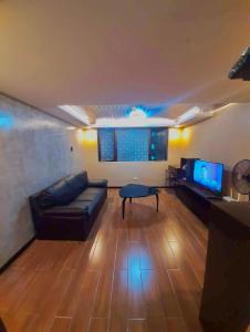 sala de estar con sofá y TV en IV’s Condo w/ Netflix and Wi-Fi en Cainta