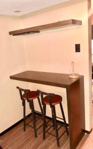 a counter with two stools sitting at a table at IV’s Condo w/ Netflix and Wi-Fi in Cainta