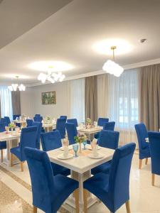 een conferentiezaal met blauwe stoelen en tafels bij South Hotel in Tasjkent