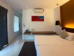 a bedroom with a bed and a bench in it at Cede Boutique Beach Resort in Ko Phayam