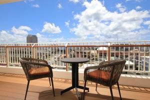 balcone con 2 sedie e tavolo di Terrace Garden Mihama Resort a Chatan
