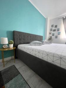 a bedroom with a large bed and a side table at Patrick Home in Cluj-Napoca