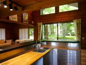 eine Küche mit einem Waschbecken und einem großen Fenster in der Unterkunft Forest Villa Yamanakako in Yamanakako